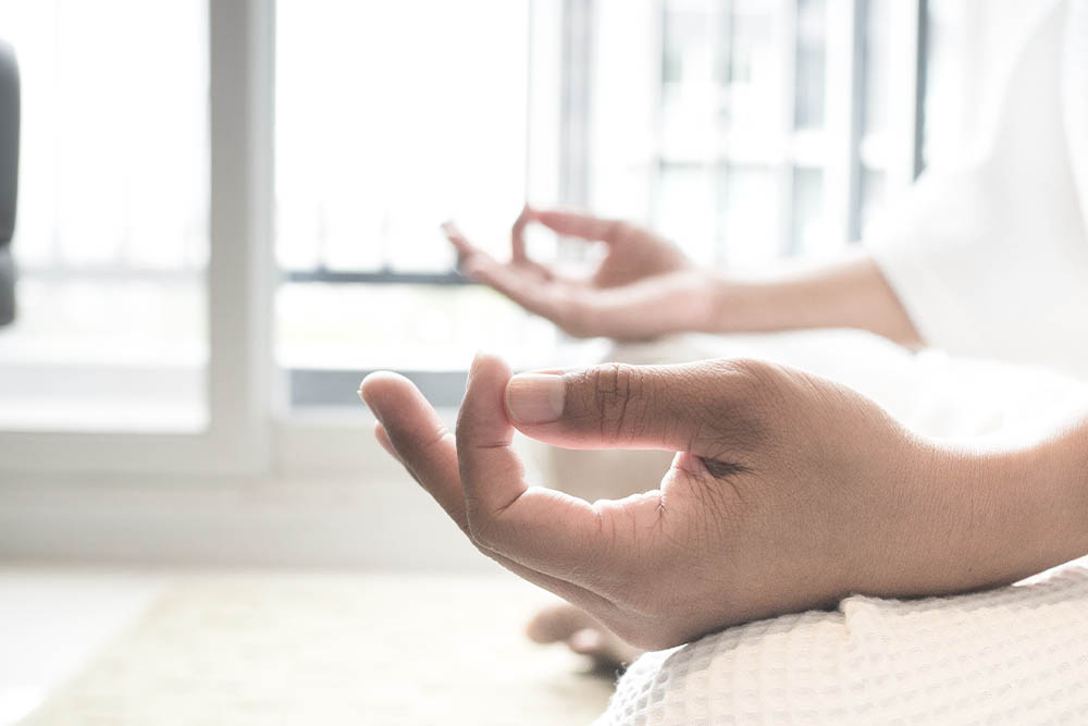 Mãos em posição de yoga - Meditação pousadas nos joelhos. Meditação para controlar ansiedade