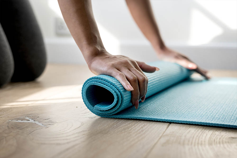 Close em mãos femininas enrolando Tapete para Yoga Antiderrapante